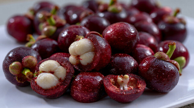 Heap of fresh purple mangosteen fruits on a white plate with mangosteen tropical nutrition