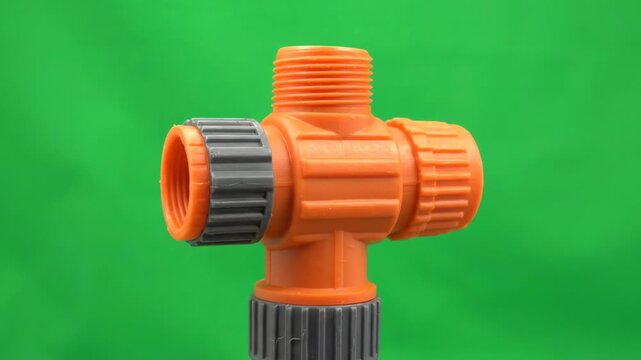 Plastic garden hose connector rotating slowly against a solid green screen background for easy keying and composting