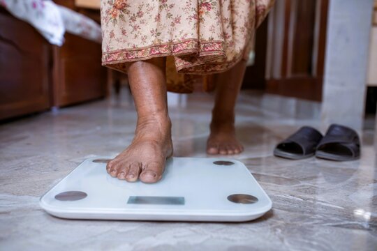Home dialysis patient foot on bathroom scale indoor health check weight monitoring elder care comfort balance