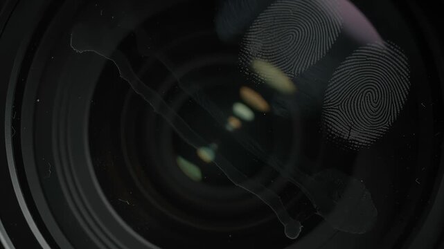 Soft white fingerprint smudges and oily streaks on lens on black background.