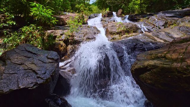 Ngao Waterfall in Namtok Ngao National Park, Ranong, Thailand, is a spectacular mountain waterfall cascading down a steep cliff, surrounded by lush tropical rainforest during the rainy season.