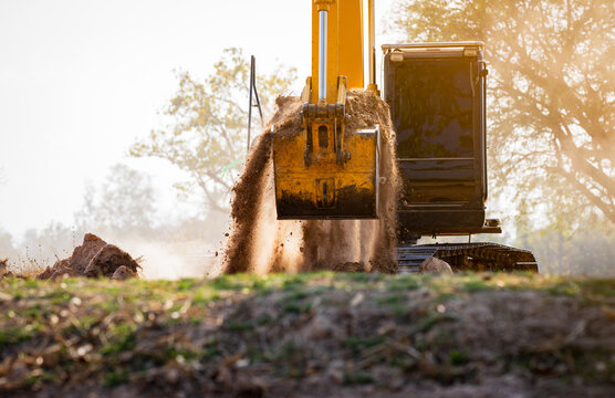 Backhoe working by digging soil at construction site.  Crawler excavator digging on demolition site. Excavating machine. Earth moving machine. Excavation vehicle. Construction business.