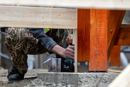 La Tuque, Quebec, 11 May 2026 : A person uses a Makita cordless drill to fasten wooden beams during construction of an outdoor structure.