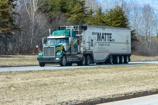 Quebec, Canada, 24 April 2026 : A green Western Star semi-truck with a Groupe Matte Enr. bulk transport trailer drives on a road.