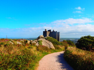 Winding gravel path leading up to a historic stone castle on hill © Tib