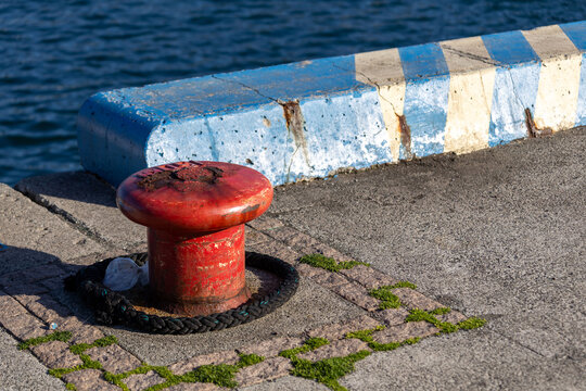 Red mooring bollard on a harbor pier