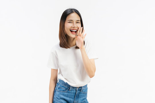 Happy Asian business woman shouting and hands over mouth on white color background.