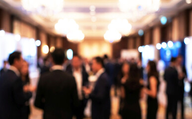 Fototapeta premium A blurred scene of a networking event with people engaging in conversation, showcasing a lively atmosphere and elegant venue interior.