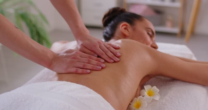 Close-up of masseuse providing back massage in spa salon, offering luxury therapy and treatment for body care and relaxation in a professional setting with focus on wellness and comfort.