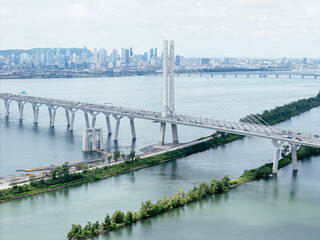 Fototapeta premium Aerial view of Brossard suburban Montreal skyline beyond the river and bridge. g