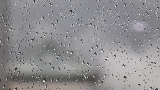 Tiny Rain Droplets Resting On Window Glass Against Soft Cloudy Sky Background View