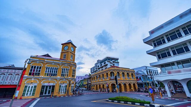 Time lapse Blue hour view of the historic clock tower in Phuket Old Town, Thailand, featuring beautifully preserved Sino-Portuguese architecture, dramatic clouds, and motion-blurred city traffic.