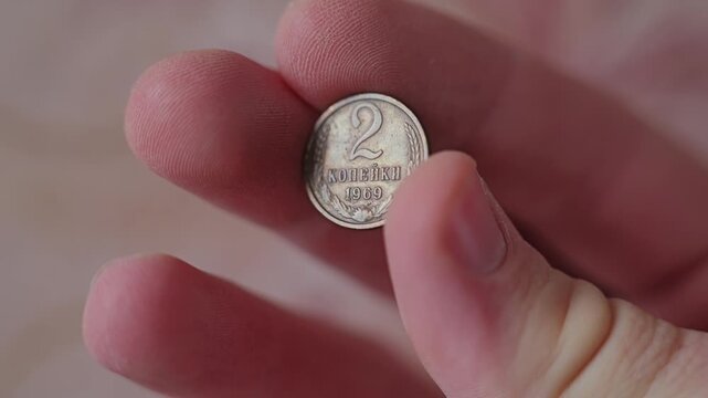 Man holds a Soviet 2 kopeck coin from 1969 as historical relic in close up