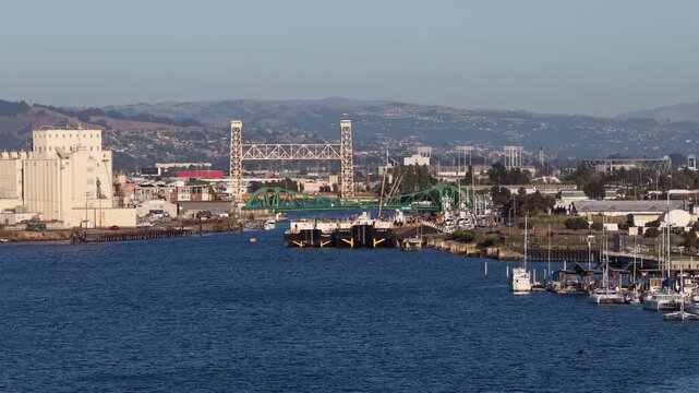 Aerial view of the Park Street Bridge, a bascule bridge, opening to allow a boat to pass through the Oakland Estuary connecting Oakland and Alameda, California, during a sunny day