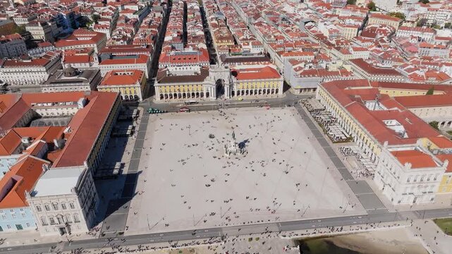 Praca do Comercio and Rua Augusta Arch in central Lisbon Portugal, drone establishing medium overview at midday as tourists roam plaza