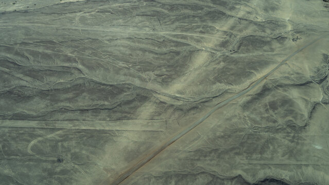 The Nazca Desert. Aerial view from an airplane. Mysterious drawings, intersecting straight and curved lines are visible on the sand of the plateau. Peru.