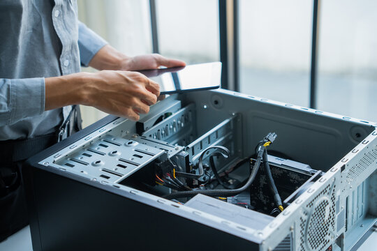 Asian IT engineer holding tablet using AI helping fix pc case