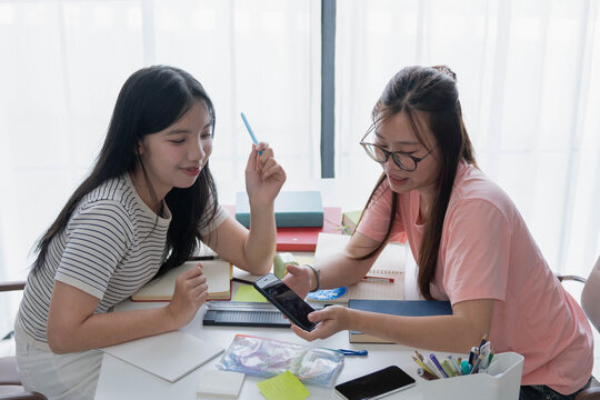 Two Asian girl using smartphone search data for homework