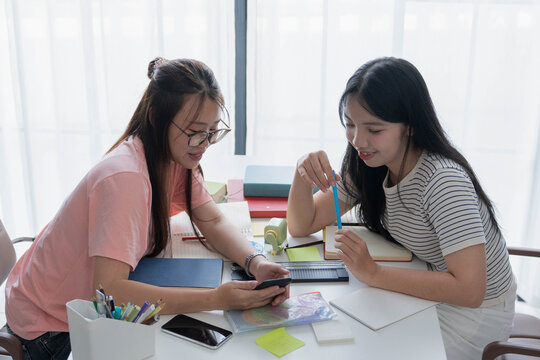 Two Asian girl using smartphone search data for homework