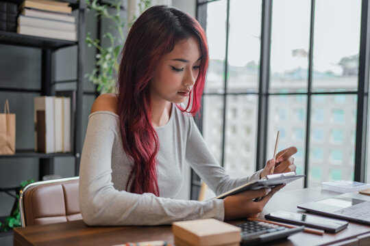 Woman managing small business accounts and recording sales revenue and expenses business income financial management entrepreneurship .