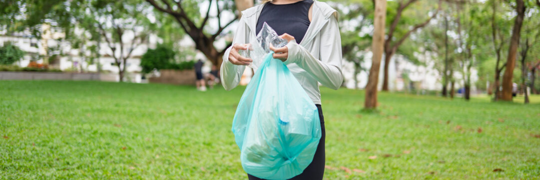 Asian Gen Z woman plogging and collecting trash in green urban park for representing sustainability wellness and positive active lifestyle