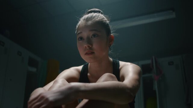 Young Gymnast Looking Lost and Anxious in Dim Dressing Facility. Female Processes Fear of Defeat, High Competition Anxiety, Psychological Stress Felt by Generation Z Athletes Before Major Tournament.