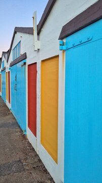 Colourful vintage boat sheds painted blue, yellow and red at harbour marina in capital city of Wellington, New Zealand Aotearoa