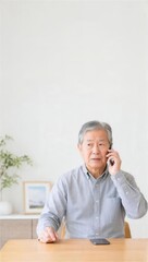 Fototapeta premium スマートフォンにかかってきた不審電話に警戒するシニア男性