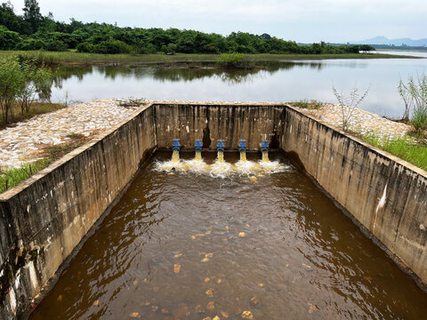 Agricultural irrigation system concrete spillway structure, showcasing rural water resource management, drainage pipes discharging inflow, reservoir hydraulics, and civil engineering