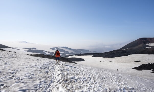 Hiker on snow field, Barren hilly volcanic landscape of snow and lava fields, Fimmv&ouml;r&eth;uh&aacute;ls hiking trail, &THORN;&oacute;rsm&ouml;rk Nature Reserve, Su&eth;urland, Iceland