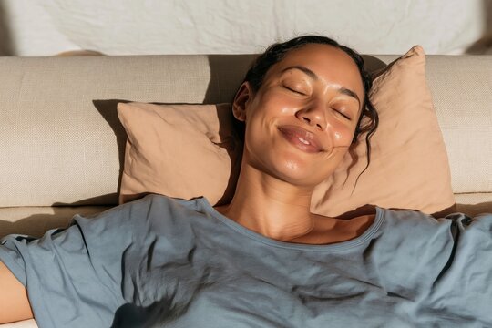 Young woman with a deep skin tone resting eyes closed on a sofa, peaceful and radiant home interior for wellness and self-care content