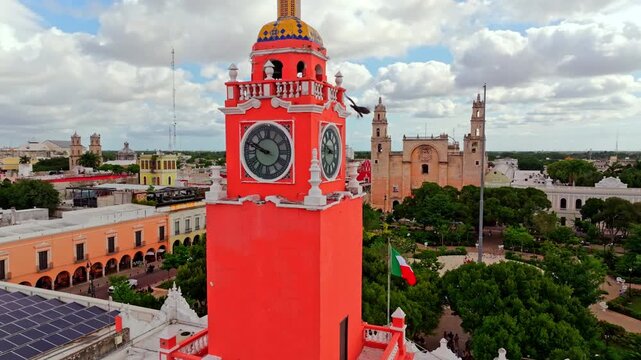 Aerial view of the historic centre of Merida, Yucatan, Mexico, a red colonial building with a clock tower standing among the colonial rooftops.