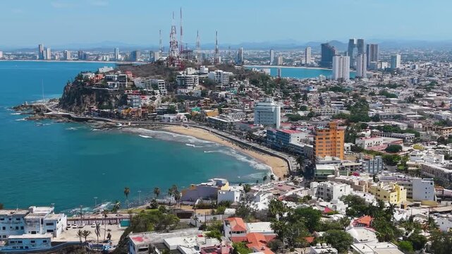A sweeping, high-altitude aerial view capturing the dense integration of Mazatl&aacute;n&rsquo;s urban development and coastal beachfront.