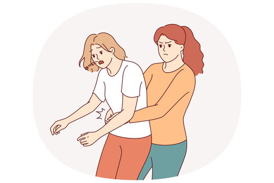 Heimlich technique is demonstrated by woman saving friend who was choking and pressing on stomach to restore breathing. Girl provides first aid and uses heimlich technique to avoid harm to health.
