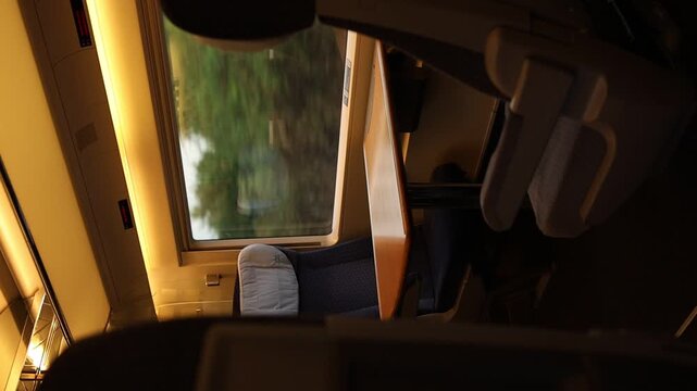 Empty passenger seats and table inside a modern train carriage.