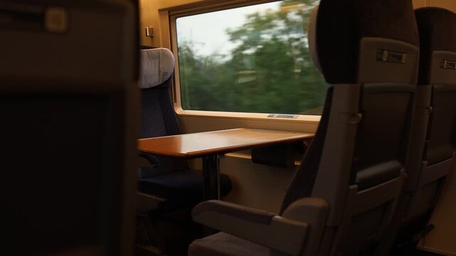 Empty passenger seats and table inside a modern train carriage.