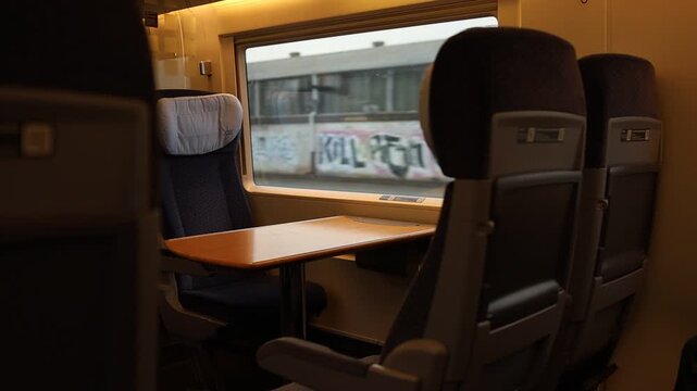Empty passenger seats and table inside a modern train carriage.