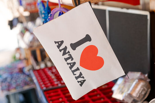 White Pouch Bag with Antalya Heart Logo Hangs at Souvenir Bazaar Shop