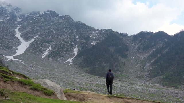Hiker trekking in mountains. Traveler exploring Kareri Lake, Kangra, Himachal Pradesh.