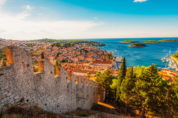 Obraz premium Hvar town and Pakleni Islands viewed from the medieval Spanish Fortress, golden hour over the Adriatic sea, Croatia.