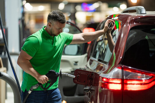 Fuel price rise impacts transportation budget. Driver pumping gas notices cost. High gasoline price affects travel plans. Inflation drives fuel expense upward.