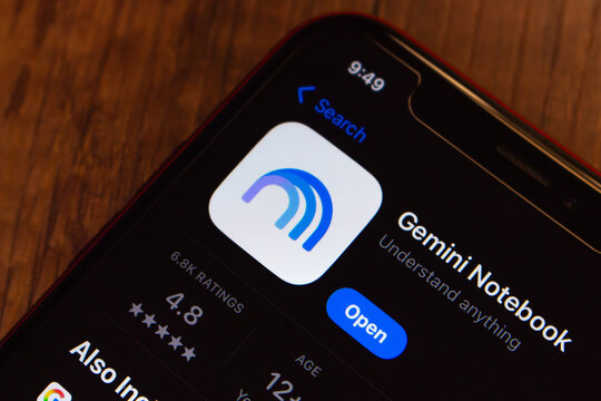 Mexico City, MEXICO - Jul 21 2026 : Smartphone on a wooden surface showing the Gemini Notebook app listing on the App Store, with the tagline Understand anything, and an Open button.