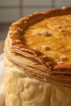 Plano de detalle de pastel de hojaldre dorado con capas crujientes y superficie glaseada