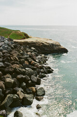 Fototapeta premium Sunlit rocky shore with sparkling ocean water