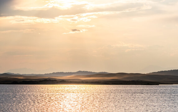 Golden sunset light reflects on a tranquil lake