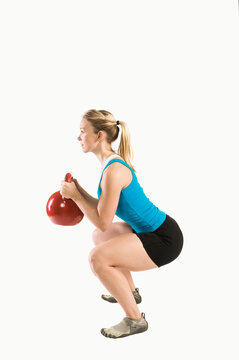 Woman performing goblet squat with kettlebell