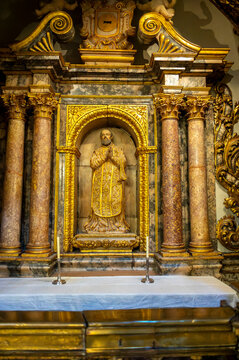 Ornate gilded side chapel retable with saint sculpture and bronze railing inside the Cathedral of San Salvador, La Seo in Zaragoza, Spain.