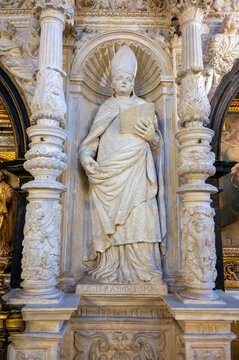 Vertical view of a finely carved stone statue of Saint Valerius (San Valero) in bishop vestments holding an open book, positioned within a shell-topped niche framed by ornate plateresque columns on th