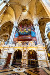 Obraz premium Low angle wide view of the ornate retrochoir and monumental organ under starry ribbed vaults inside La Seo Cathedral in Zaragoza, historic gothic and renaissance architecture.