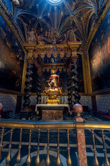 Vertical view of the Chapel of Saint Peter Arbués featuring a baroque ciborium with Solomonic columns, statue, and gothic ribbed vault in the Cathedral of San Salvador, La Seo in Zaragoza, Spain. © javier
